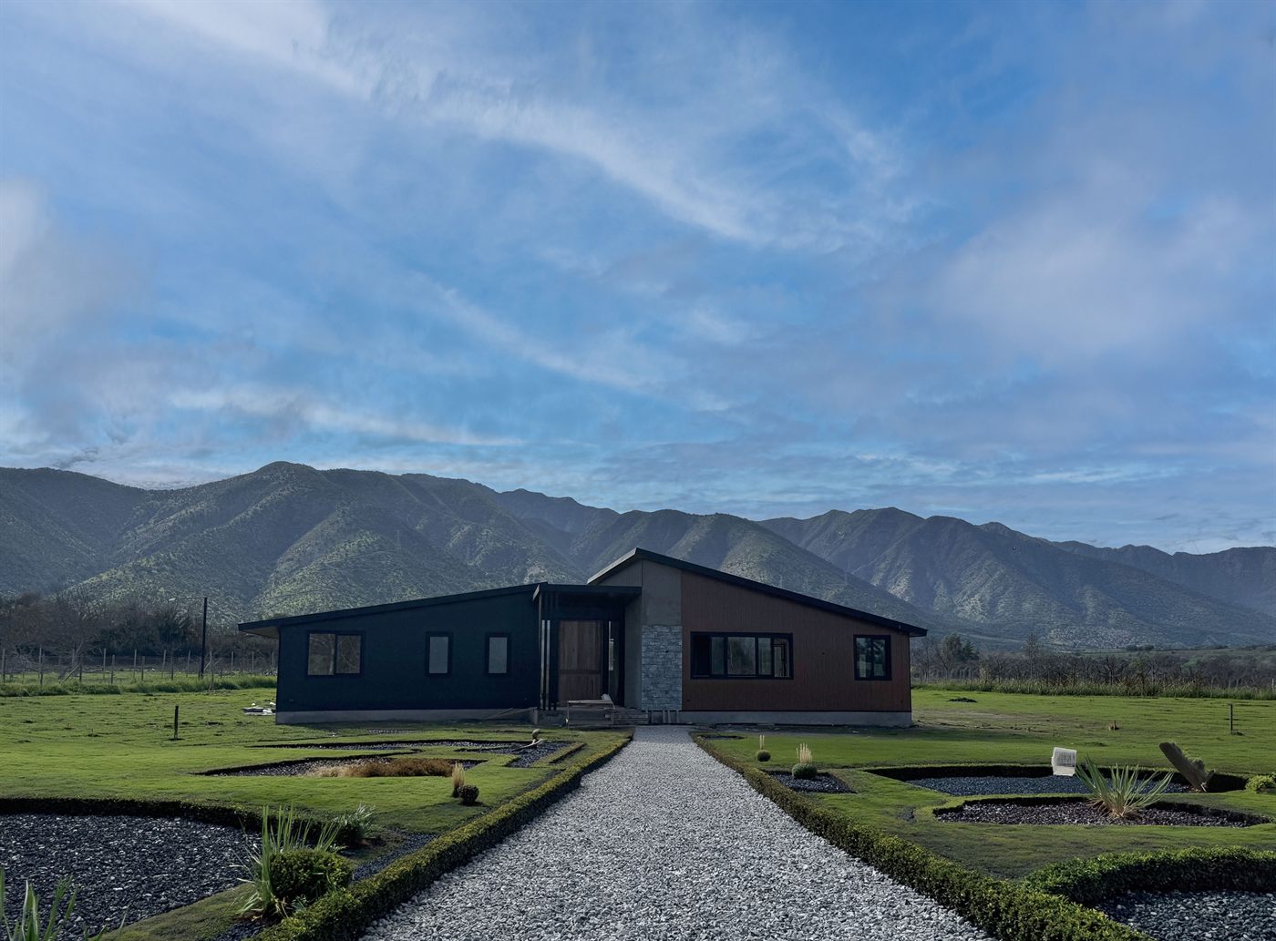 Casa con jardín y camino de acceso, con la cordillera detrás