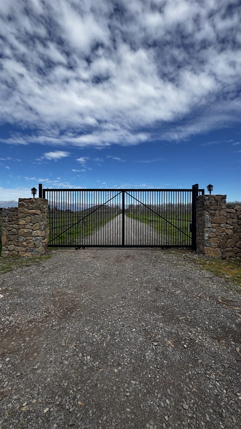 Portón de acceso a Santa Luisa de Palpi con la cordillera al fondo